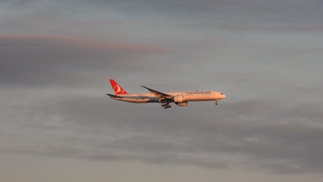 Turkish-airlines-airplane-prepares-for-landing-against-sunset-sky,-tracking