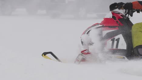 Polaris-Schneemobil-Rennfahrer-Mit-Darüber-Fliegendem-Schnee-In-Zeitlupe