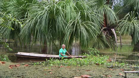 Old-Women-Paddling-Away-On-Boat-On-Lake-In-Iquitos,-Peru