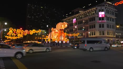 View-over-traffic-next-to-Chinese-New-Year-Pig-decorations-in-Chinatown,-Singapore---Wide-static-shot
