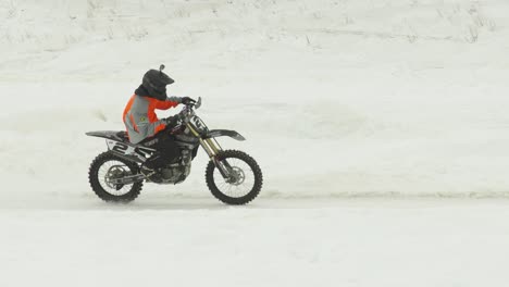 Snowcross-Motocross-Rennfahrer-Mit-Stollenreifen-Fährt-Beim-Eisbahnrennen-In-Die-Kurve