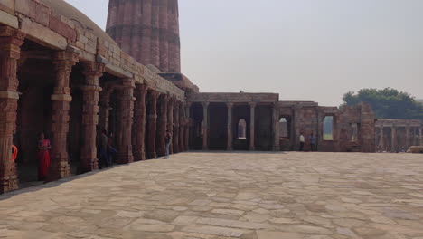 Tourist-Im-Innenhof-Des-Ikonischen-Denkmalkomplexes-Qutb-Minar,-Neu-Delhi,-Indien---4k