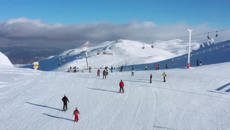 Forward-aerial-of-people-skiing-and-chair-ski-lift-in-sunny-Jahorina