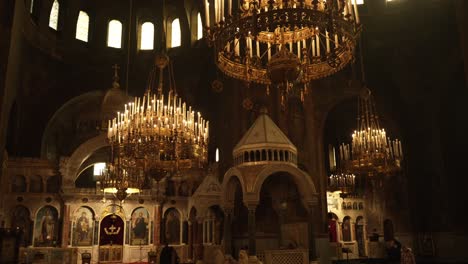 Inside-Eastern-Orthodox-cathedral-with-grand-chandeliers-with-lighted-candles