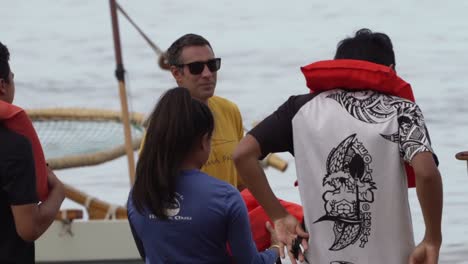 Turistas-Adolescentes-Poniéndose-Chalecos-Salvavidas,-Preparándose-Para-Navegar-En-Un-Catamarán-En-Oahu,-Hawaii---Primer-Plano-Izquierdo