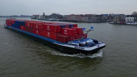 Frachtschiff-Belicha,-Beladen-Mit-Industriecontainern,-Segelt-über-Den-Fluss-Oude-Mass,-Südholland,-Niederlande