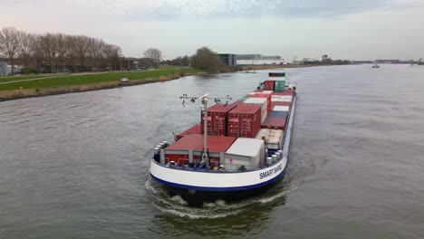 Smart-Barge-a-container-ship-sailing-through-the-river-of-Zwijndrecht,-South-Holland