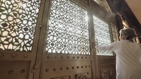 Young-Muslim-Omani-Boy-opening-Arabic-vintage-ornamented-door---Wide-push-in-shot