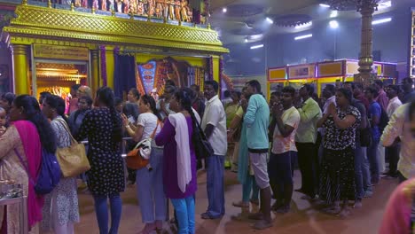 People-standing-in-line-in-Sri-Veeramakaliamman-Temple-Hindu-ceremony,-Singapore---Static-Wide-shot