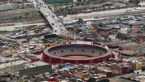 Estadio-Redondo-Al-Aire-Libre-En-Perú-Con-Tráfico-Pasando-En-Segundo-Plano.