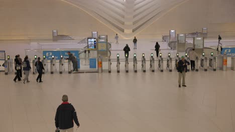 Tilt-up-of-commuter-walking-downstairs-toward-gate-of-Oculus-Westfield-World-Trade-Center-train-station-of-Manhattan-in-New-York