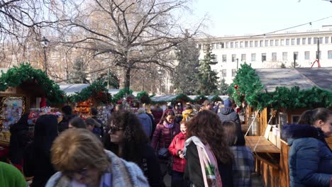 Crowd-of-people-walking-around-Christmas-market-stalls-during-daytime