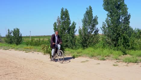 Old-uzbek-male-in-bicycle-riding-from-work-to-home