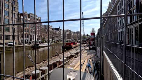 Mirando-Las-Obras-De-Fortalecimiento-De-La-Construcción-En-El-Canal-De-Ámsterdam-A-Través-De-Una-Valla-De-Alambre