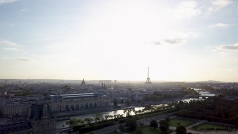 Aéreo-Cinematográfico-Drone-París-Francia-Torre-Eiffel-Famoso-Hito-Histórico-Desde-Lejos-Río-Sena-última-Hora-De-La-Tarde-Verano-Otoño-Romántico-Cielo-Azul-Brillante-Sol-Rodeado-De-Edificios-Movimiento-Hacia-Adelante