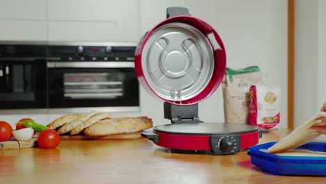 hands-putting-dough-in-electric-bread-maker,-diy