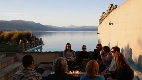 Eine-Gruppe-Von-Freunden-Sitzt-Am-Kamin-Und-Trinkt-Bier-Mit-Spektakulärem-Blick-Auf-Mount-Cook-Und-Lake-Pukaki