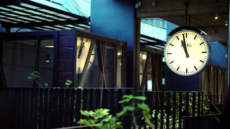 Blurred-female-in-front-of-train-station-clock-style-in-Paseo-Italia-Station,-Shopping-mall