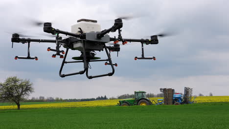 Modern-Farming,-Agriculture-Sprayer-Drone-and-Tractor-in-Green-Countryside-Field