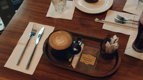 Mug-Of-Coffee-With-Latte-Art-Served-On-The-Wooden-Table-In-The-Coffee-Shop