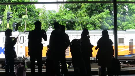 Passengers-waiting-for-the-arrival-of-the-train-at-Tugu-station,-Yogyakarta--slow-motion