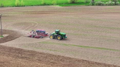 Aerial-View-of-Tractor-on-Agricultural-Field-Plowing-Land,-Tracking-Drone-Shot