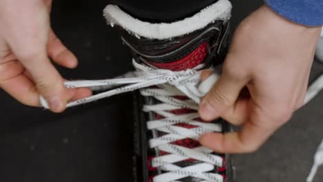Hockey-player-tying-up-their-skates-in-a-change-room