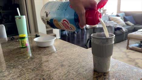 Person-pouring-creamer-into-morning-coffee,-slow-motion