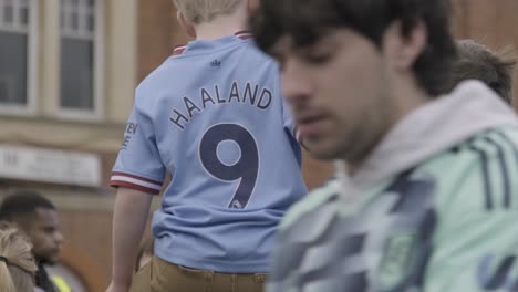 Manchester-City-fan-sitting-on-top-of-his-fathers-shoulders-wearing-an-Erling-Haaland-shirt