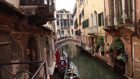 Gondoliere-Wartet-In-Seiner-Gondel-In-Einem-Kleinen-Venezianischen-Kanal-In-Venedig,-Italien