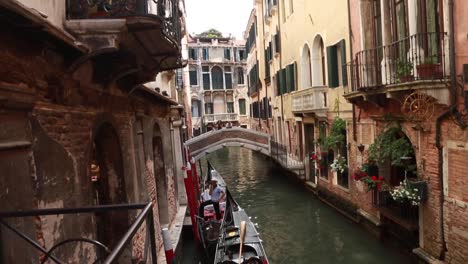 Gondolero-Esperando-En-Su-Góndola-En-Un-Pequeño-Canal-Veneciano-En-Venecia,-Italia