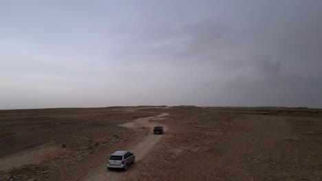 Toma-Aérea-De-Seguimiento-De-Automóviles-En-La-Carretera-En-El-Fin-Del-Mundo-En-Un-Día-Nublado.