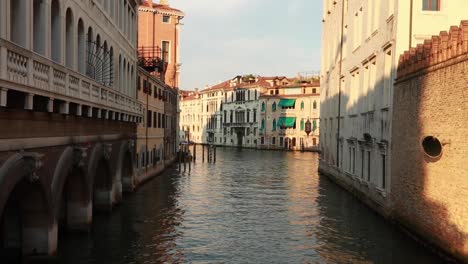 Handheld-camera-view-of-an-empty-and-calm-canal-with-classic-Venetian-architecture-buildings-in-Venice,-Italy