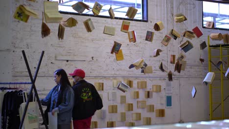 Turistas-Visitando-Y-Exposición-De-Harry-Potter-Con-Libros-Colgados-En-Bio-Bio-Market,-Santiago-De-Chile.