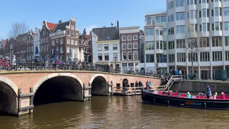 Crucero-Por-El-Canal-Con-Turistas-Pasa-Por-Debajo-Del-Puente-En-Ámsterdam,-Toma-Estática
