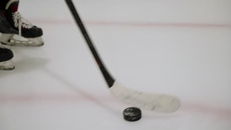 Hockey-player-training-with-a-puck-on-an-ice-rink