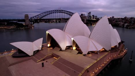 Drones-Aéreos-Orbitan-Alrededor-De-La-Famosa-ópera-De-Sydney-En-La-Noche-Con-Luces