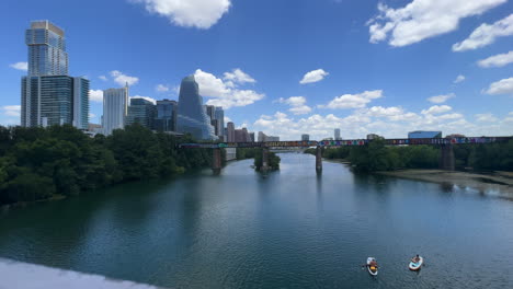 Kajakfahrer-Und-Paddle-Boarder-Auf-Dem-Ladybird-Lake-In-Austin,-Texas,-Mit-Der-Skyline-Im-Hintergrund