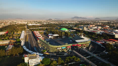 Foro-Sol-Venue-and-the-Autódromo-Hermanos-Rodríguez,-sunny-evening-in-Mexico-city---Aerial-view