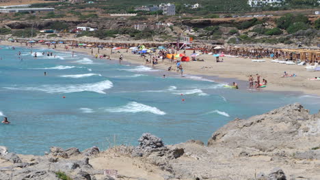 People-enjoying-Falassarna-beach-on-a-beautiful-sunny-day,-Crete