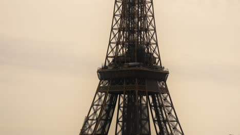 Eiffel-Tower-Paris-France,-zoomed-in-from-a-distance,-against-sunset-sky