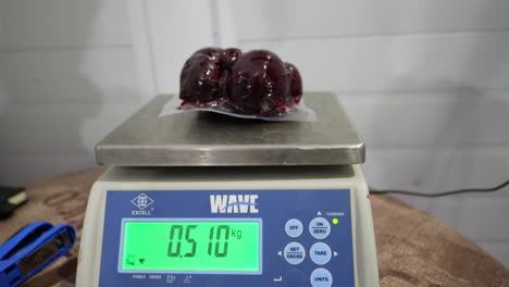 Food-worker-testing-weight-of-sealed-beet-vegetables-in-the-factory