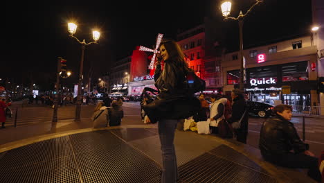 Tourists-gather-on-sidewalk-in-front-of-Moulin-Rouge-in-Paris-France,-night-time