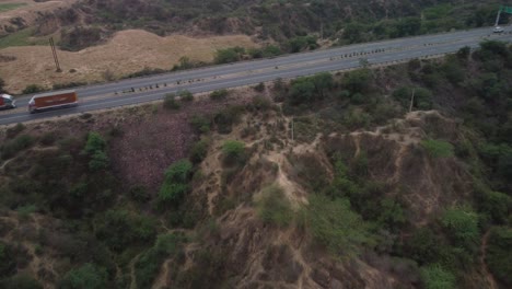 Aerial-view-of-the-Srinagar-Delhi-Chennai-Kanyakumari-national-highway-cutting-through-the-iconic-gully-erosions-in-the-badlands-of-Chambal-ravines-near-Rajasthan-Madhya-Pradesh-border,-India