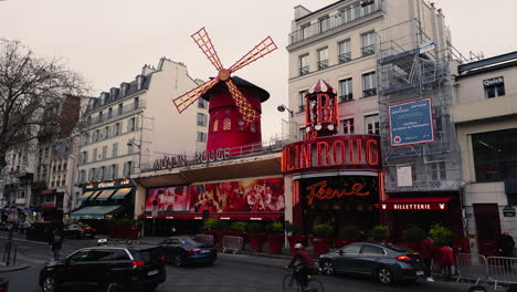 Cars-Driving-In-Front-Of-Moulin-Rouge,-Popular-Cabaret-In-Paris,-France