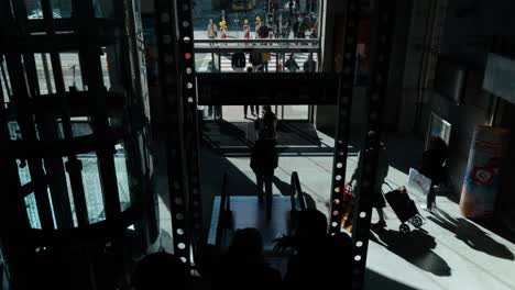 POV-of-people-silhouettes-going-down-on-electric-stairway-inside-the-modern-public-transport-station---Namur,-Belgium