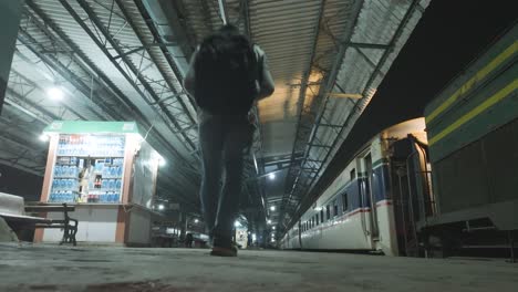 Male-Backpacker-Walking-Along-Empty-Karachi-City-Railway-Station-Platform-At-Night