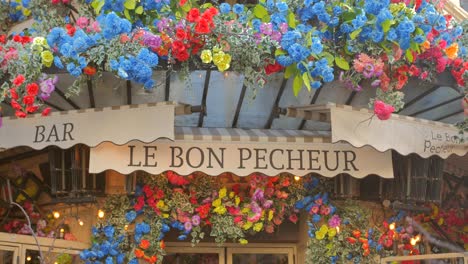París,-Francia:-Foto-De-La-Entrada-Florida-Del-Bar-Y-Restaurante-Le-Bon-Pecheur,-Decorada-Con-Flores-Coloridas-Durante-El-Día