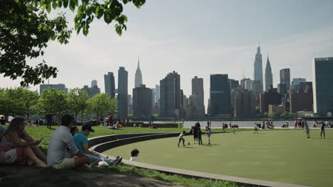 Los-Neoyorquinos-Se-Relajan-En-Un-Parque-Público-En-Queens-Con-Vistas-Al-Horizonte-Del-Centro-De-Manhattan
