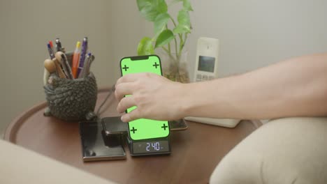 Placing-phone-with-a-green-screen-to-a-multi-purpose-charger-station